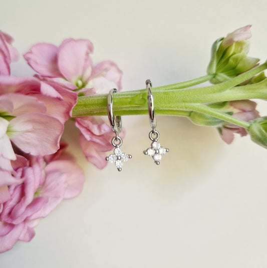 silver huggie hoops with a dainty flower pendant