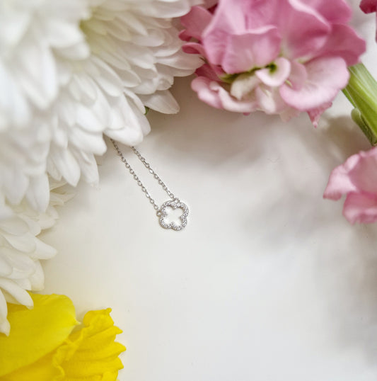 a dainty silver necklace with a small clover pendant