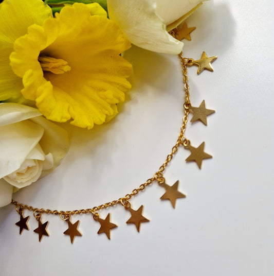 gold star choker next to flowers. front view