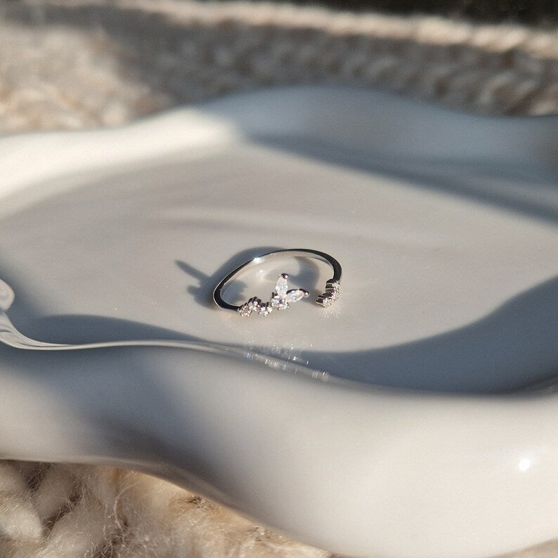 a silver butterfly ring on a jewellery dish