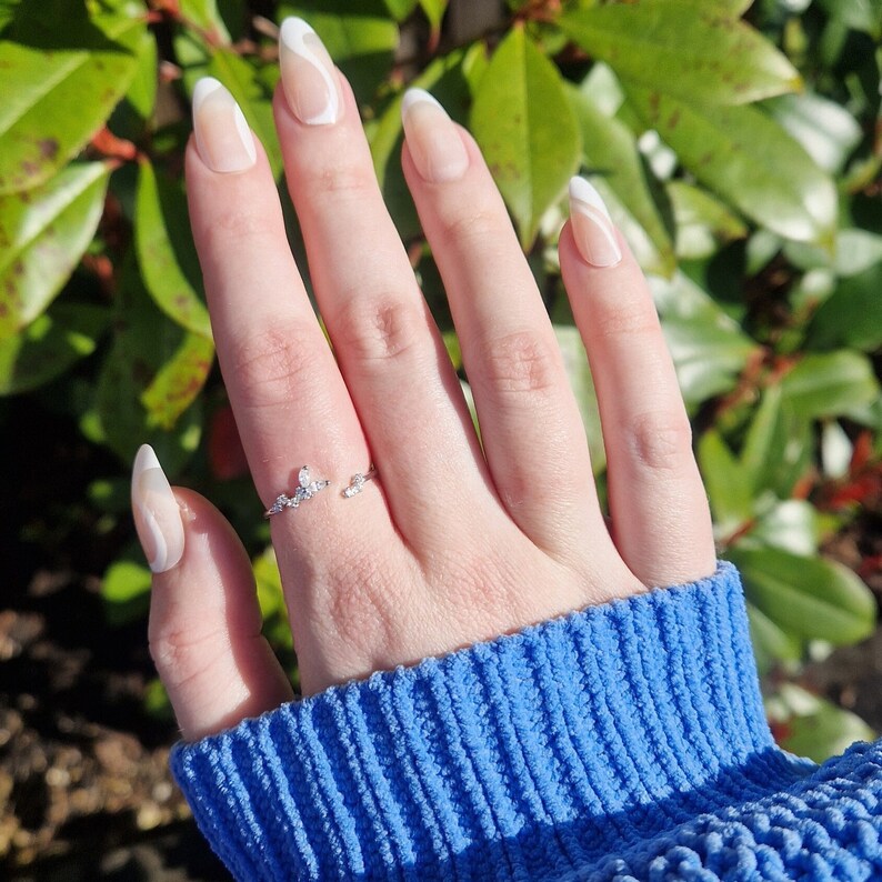woman's hand wearing silver butterfly ring